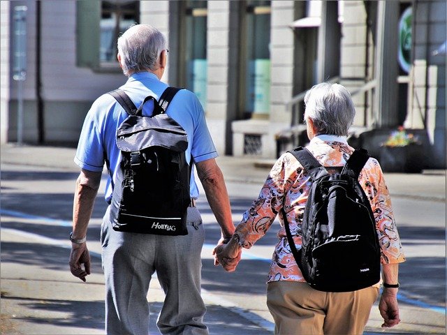 Zdjęcie dwóch seniorów z plecakami