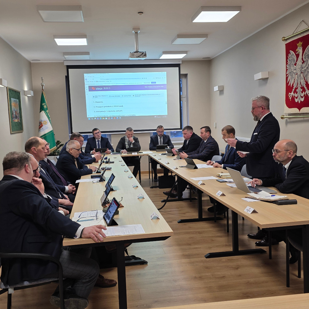 Kilka osób siedzi przy stole i obraduje 