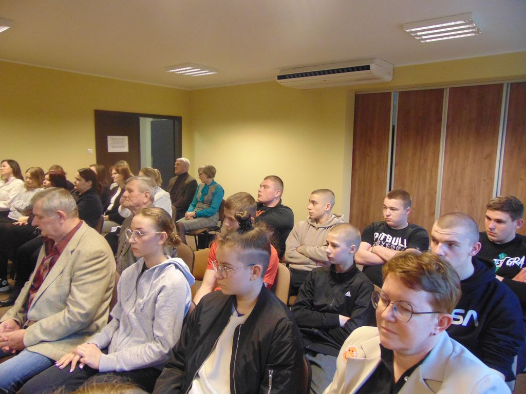 Uczestnicy spotkania siedzą w sali.
