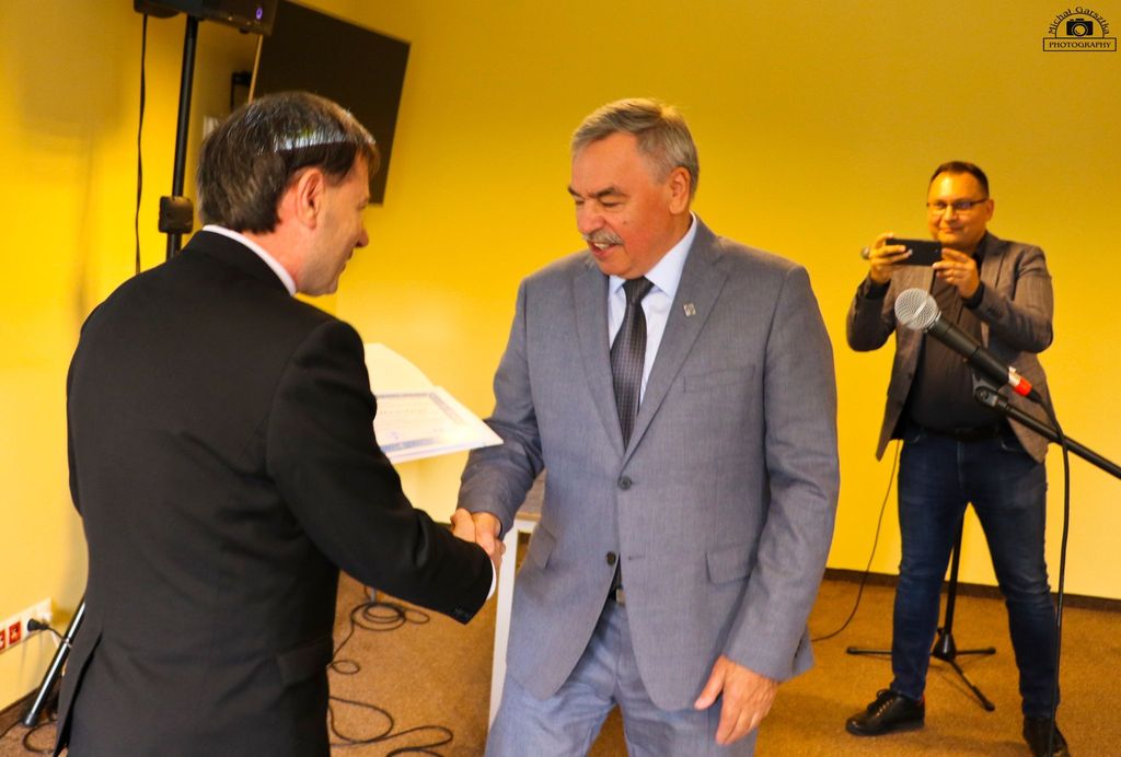 Mężczyzna wręcza autorowi dyplom